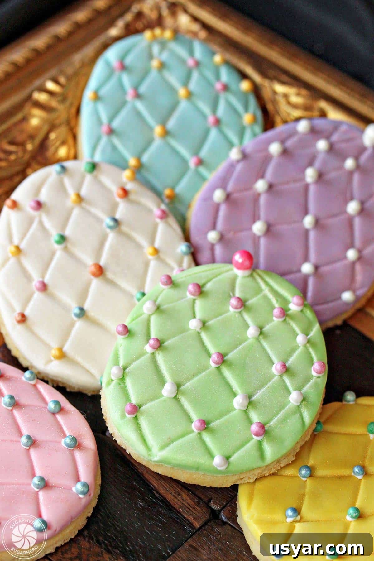 Fondant-Covered Easter Egg Sugar Cookies decorated with colorful sugar pearls Easter Egg Sugar Cookies with colorful sugar pearl accents on a gold tray