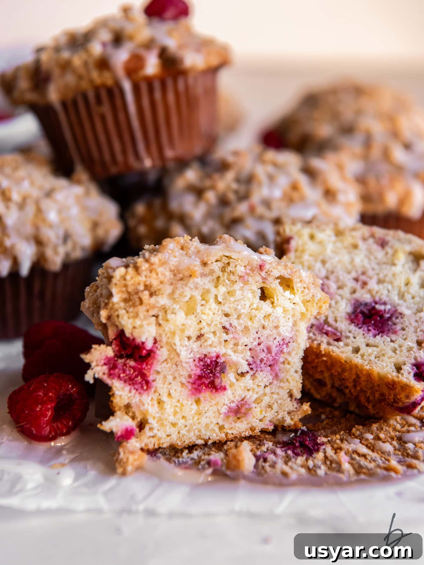 Zesty Lemon Raspberry Streusel Muffins 6 raspberry muffin cut in half showing berries inside and streusel on top.
