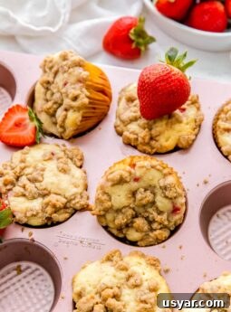 strawberry muffins with streusel topping in pink muffin pan