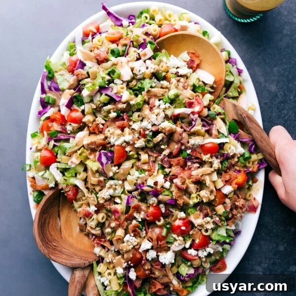 A vibrant bowl of Portillo's Chopped Salad with two serving spoons.