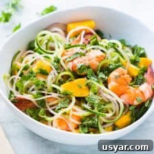 Cucumber Noodle Prawn and Mango Salad served in a white bowl.