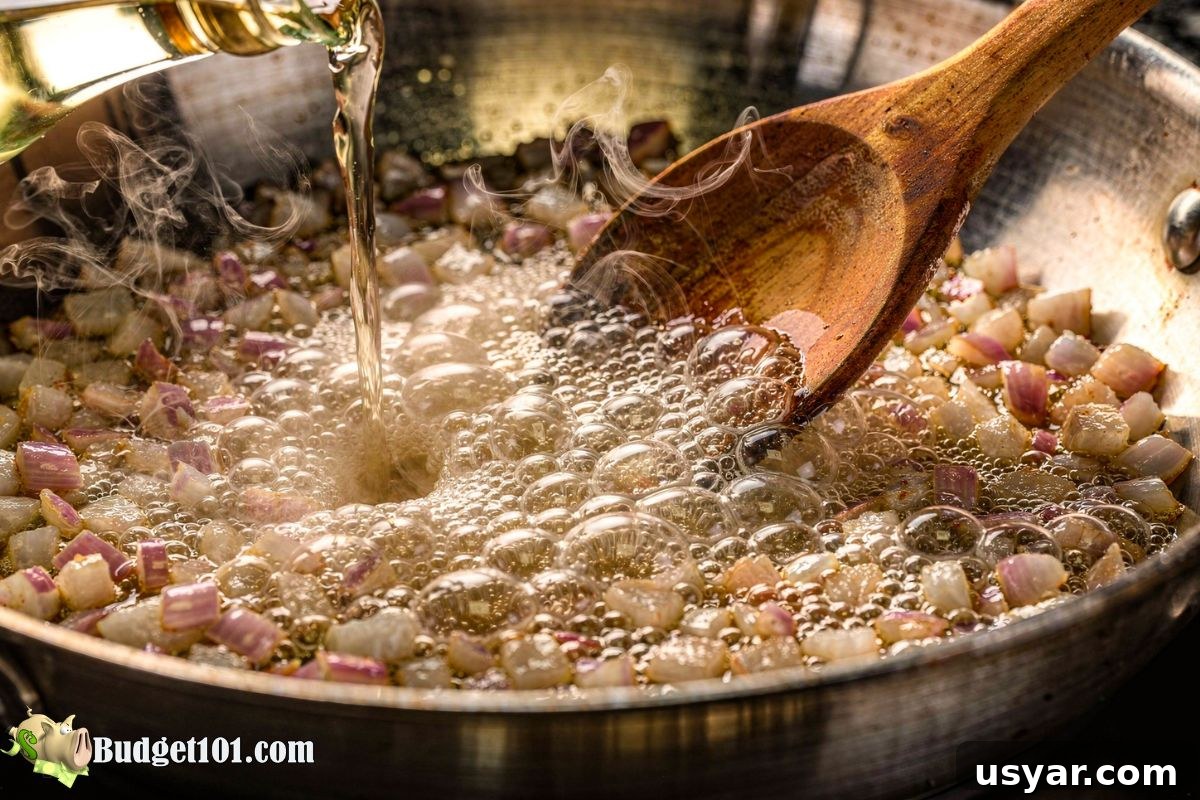 Deglazing the Pan for Maximum Flavor Pan with onions and garlic being deglazed with liquid and bubbling
