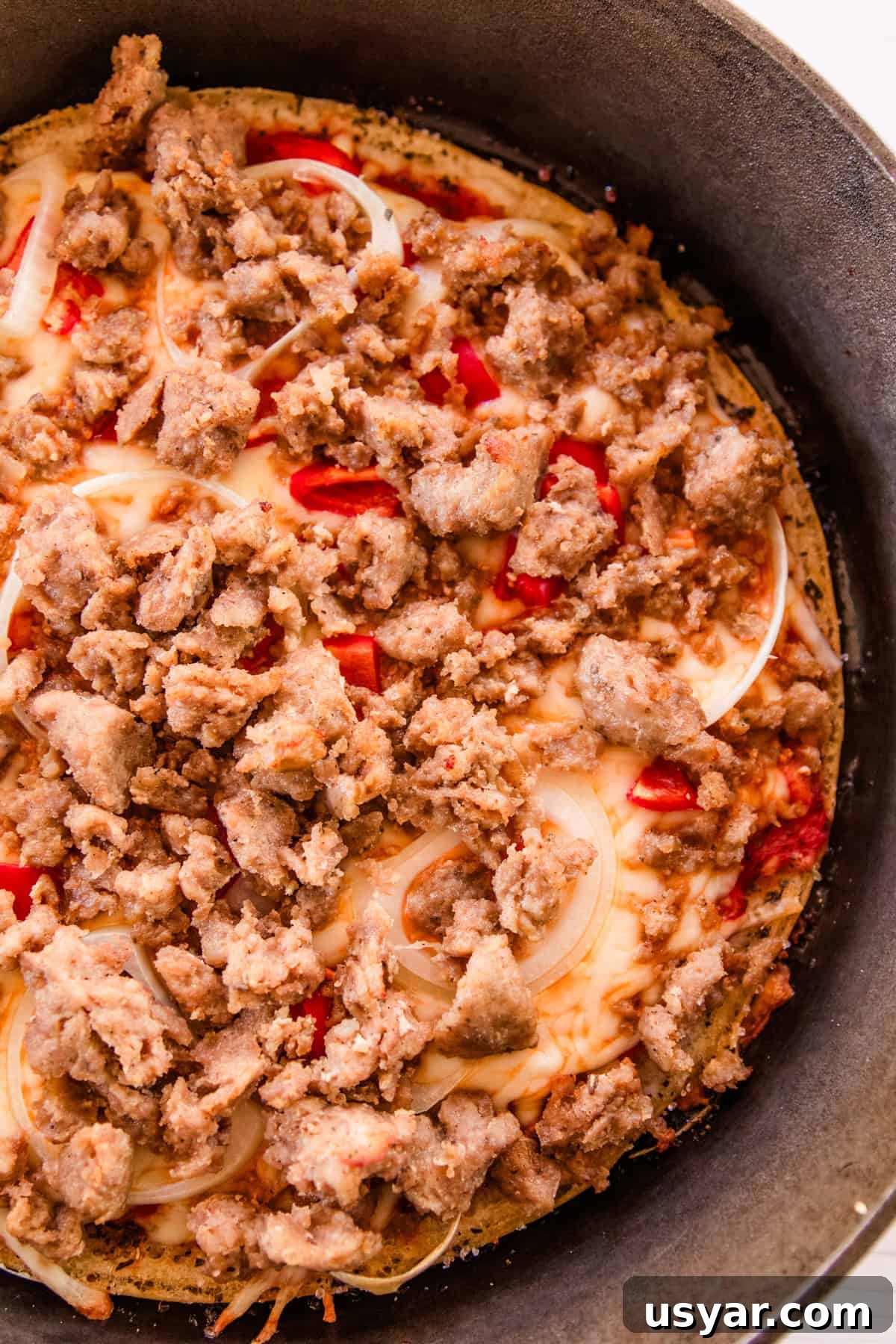 Sourdough Sausage Pizza Recipe with Crispy Golden Crust 11 A sausage sourdough pizza in a cast iron skillet.