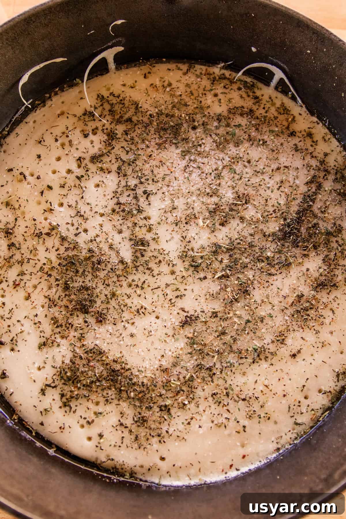 Sourdough Sausage Pizza Recipe with Crispy Golden Crust 5 Sourdough pizza crust with herbs sprinkled on it.