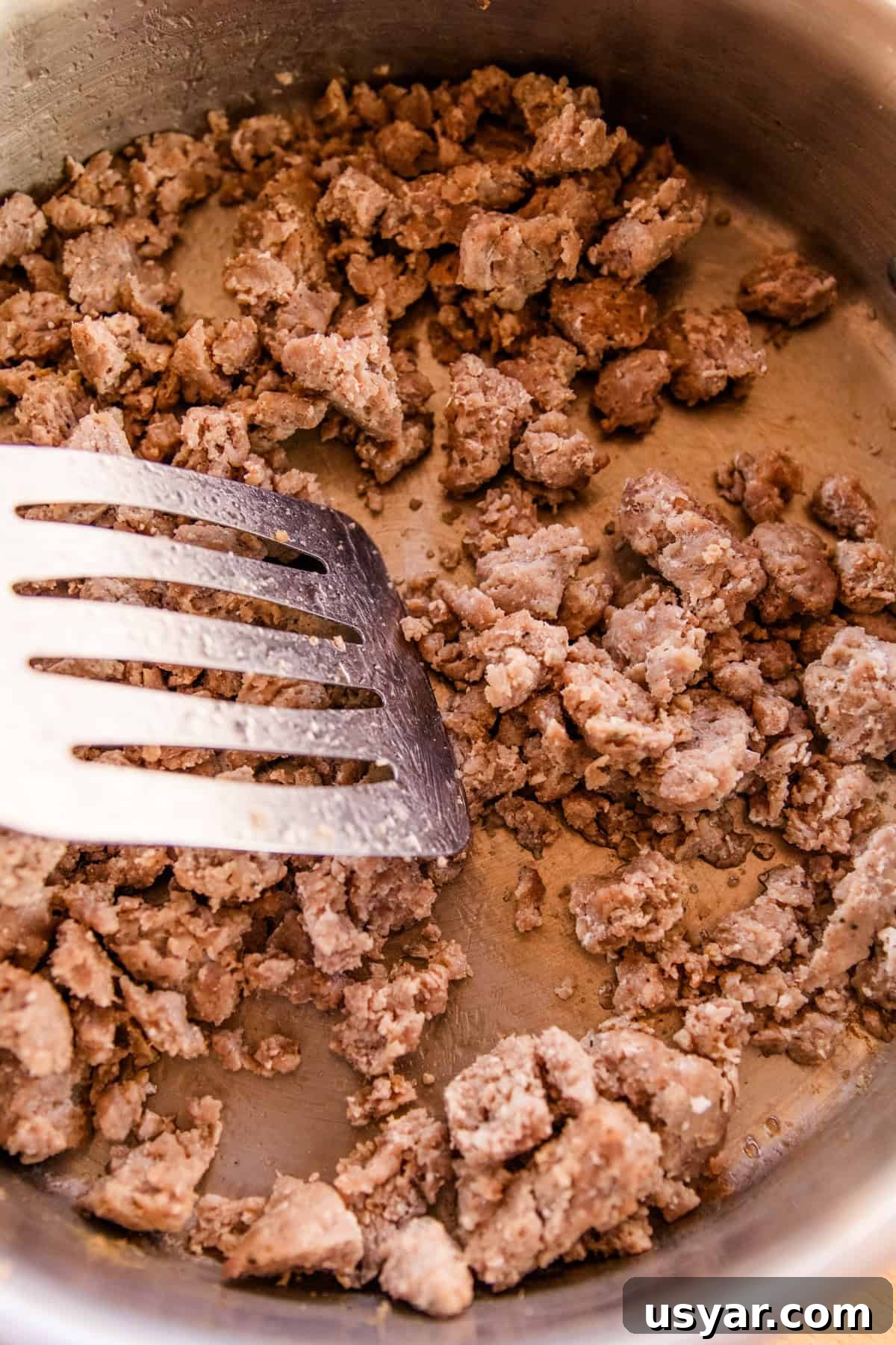 Sourdough Sausage Pizza Recipe with Crispy Golden Crust 8 Browning sausage in a cast iron skillet.