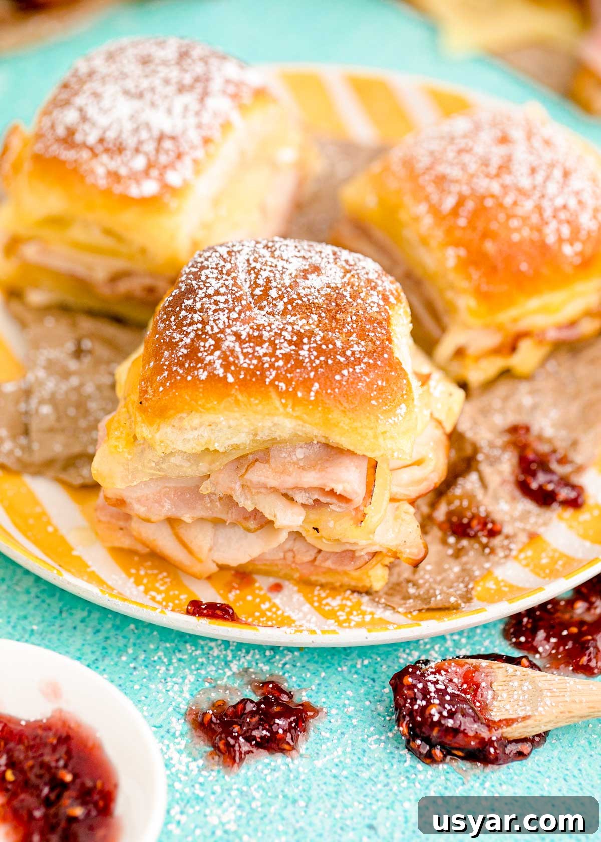 Monte Cristo Sliders on a yellow plate on a blue surface.