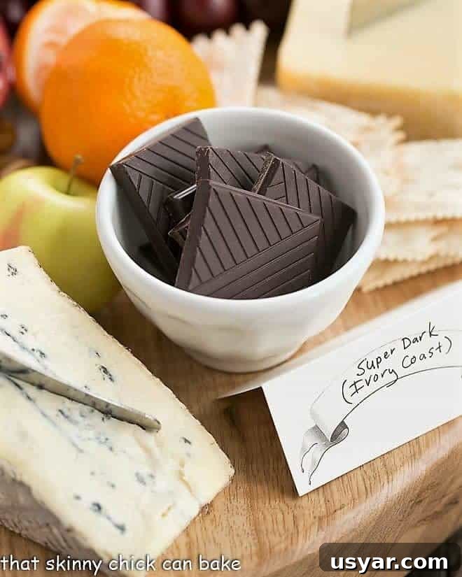 Chocolate Dessert Board - an elegant way to end a meal with top notch chocolates, fruit and cheeses artfully displayed for a jaw dropping presentation! Chocolate squares in a white bowl with blue cheese
