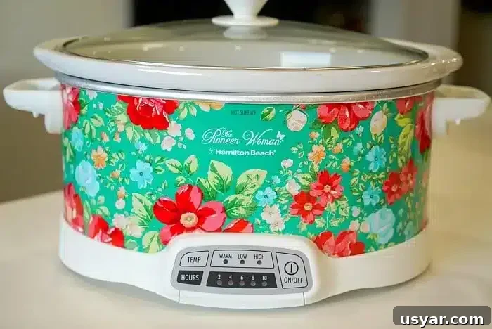Slow Cooker Cheesy Chicken Casserole Recipe 3 A floral design slow cooker with a white base and lid sits on a kitchen countertop, perfect for whipping up a 5 ingredient crockpot chili recipe.