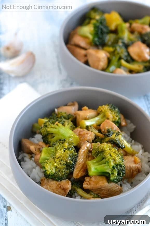 close up of Chicken and Broccoli Stir-Fry served in a grey bowl with rice