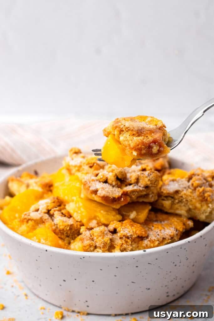 Mom's 90s Gluten-Free Peach Cobbler Recipe 4 Side image of bowl of gluten free peach cobbler being scooped out with a metal spoon