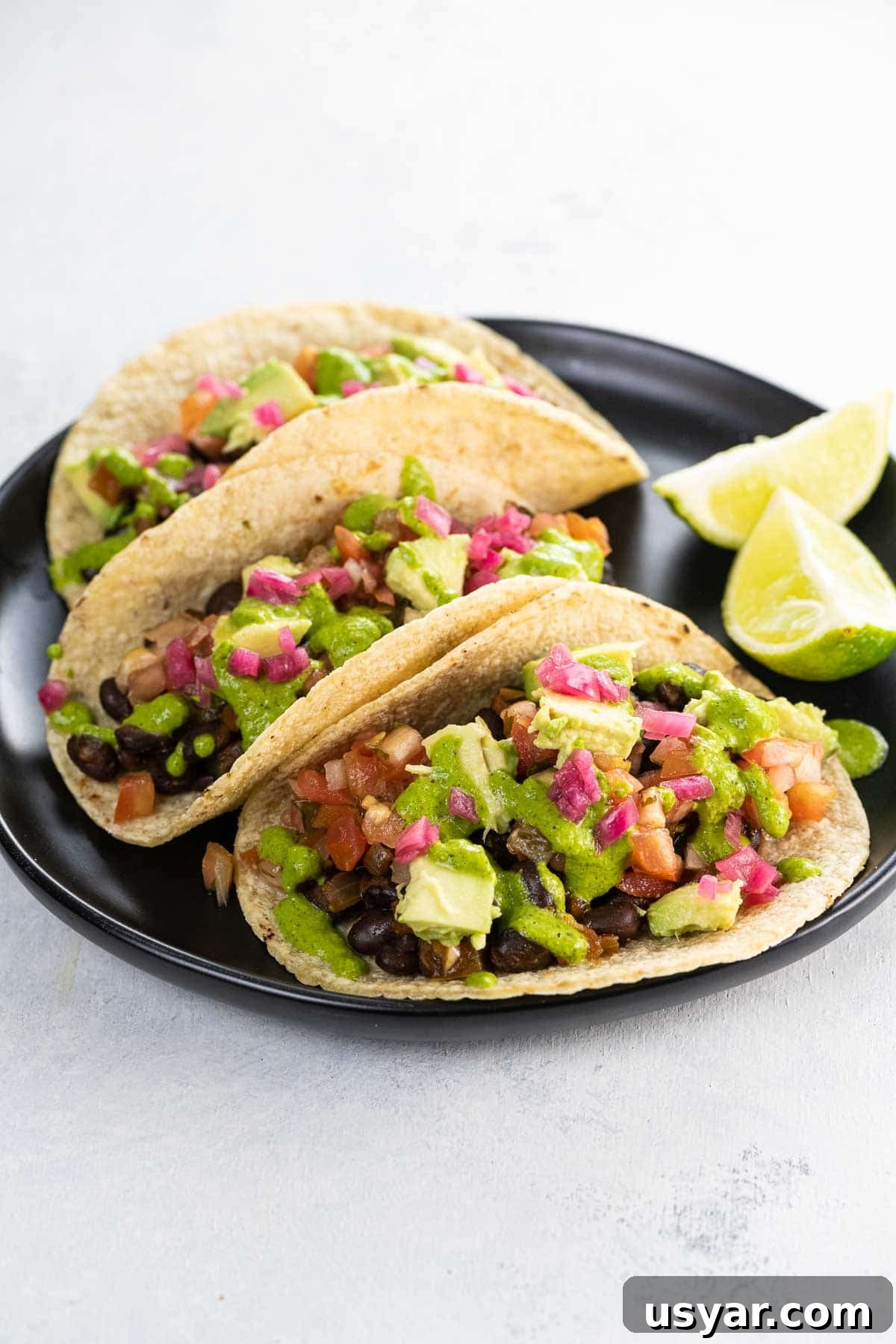 Smoky Black Bean Vegan Tacos with Avocado Lime Slaw 2 black bean vegan tacos on a plate