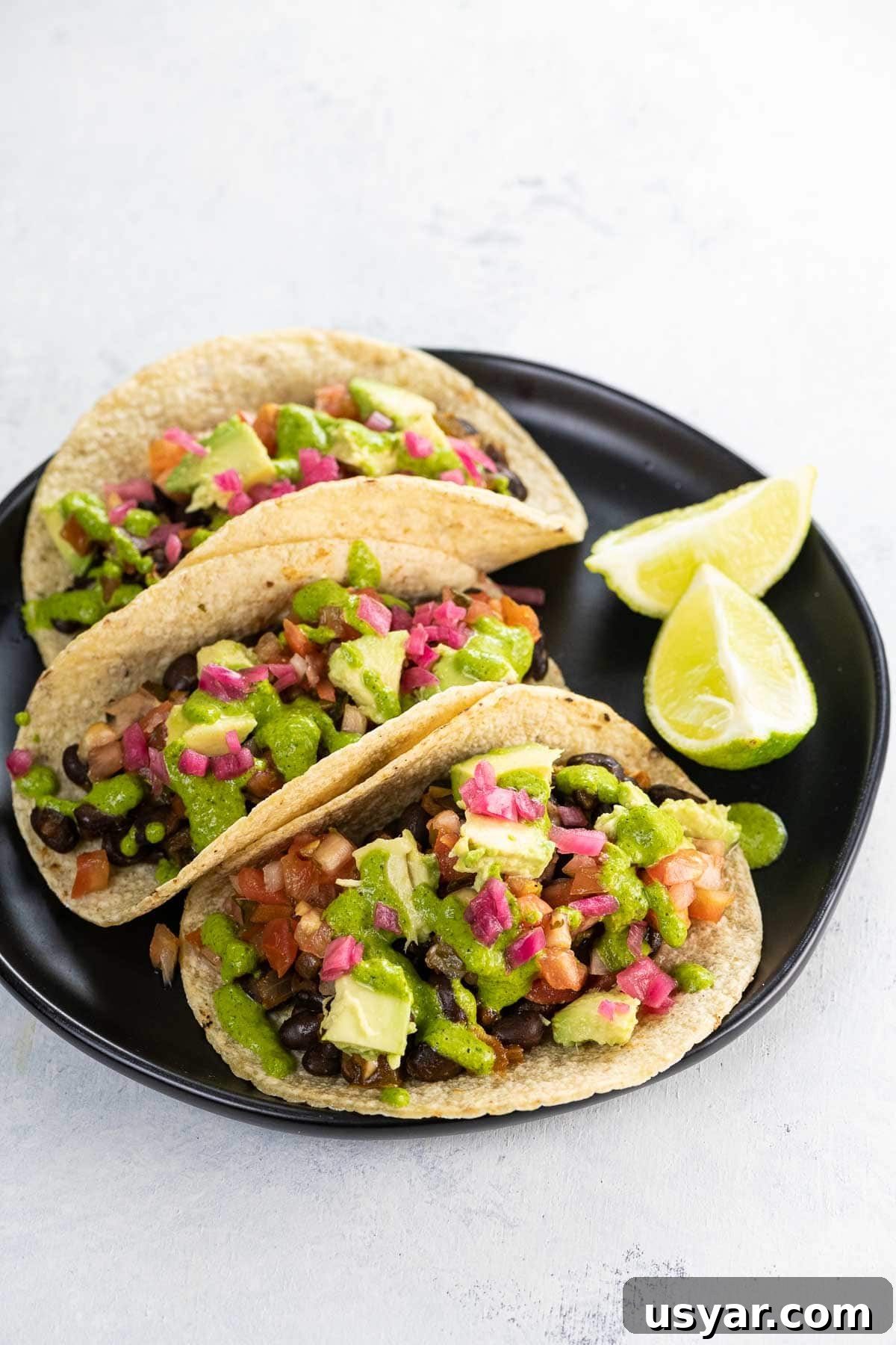 Smoky Black Bean Vegan Tacos with Avocado Lime Slaw 6 black bean vegan tacos on a plate