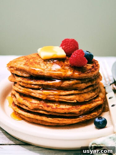High-Protein Cottage Cheese Pancakes Recipe 16 A stack of High Protein Cottage Cheese pancakes on a plate with berries.