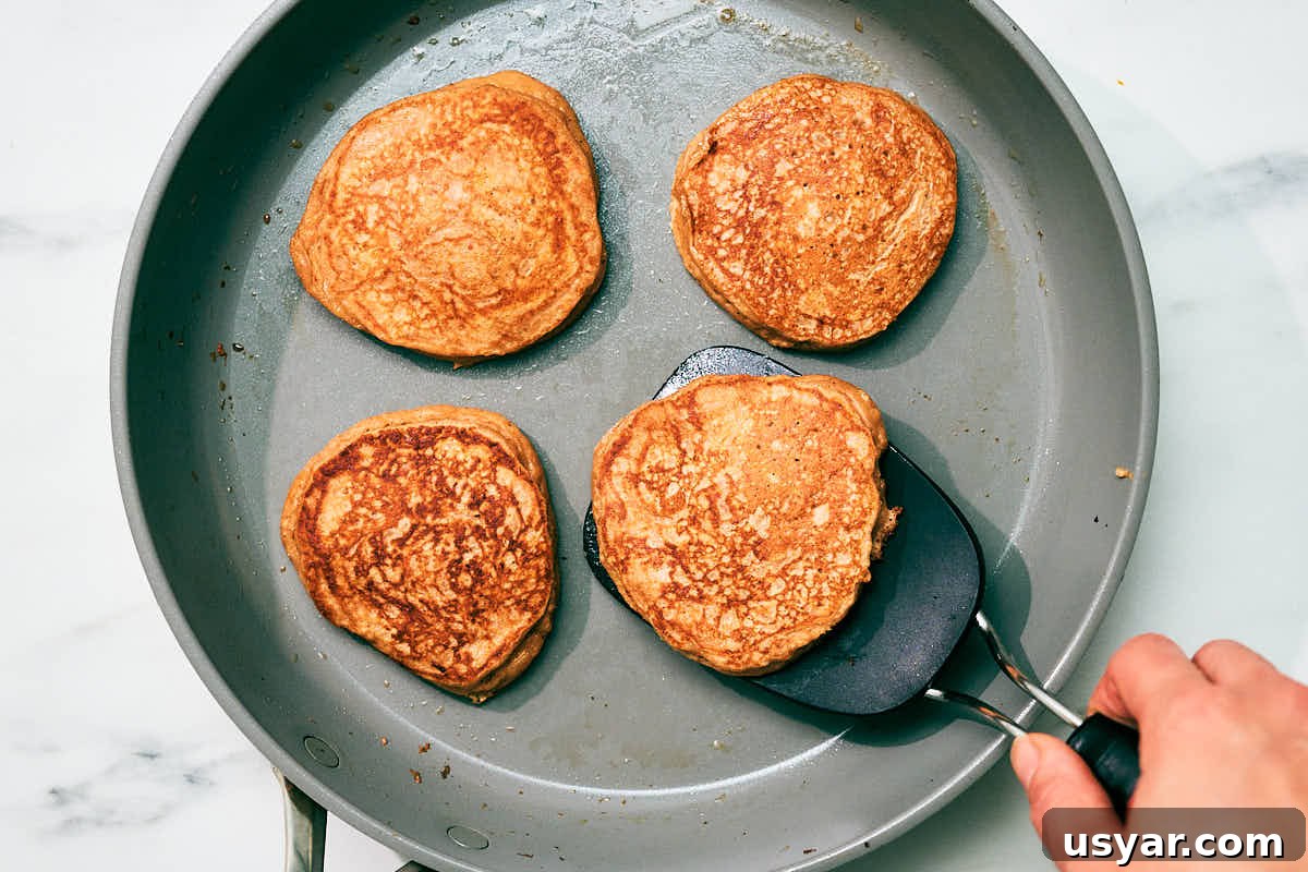 High-Protein Cottage Cheese Pancakes Recipe 10 High protein cottage cheese pancakes being cooked in a skillet.