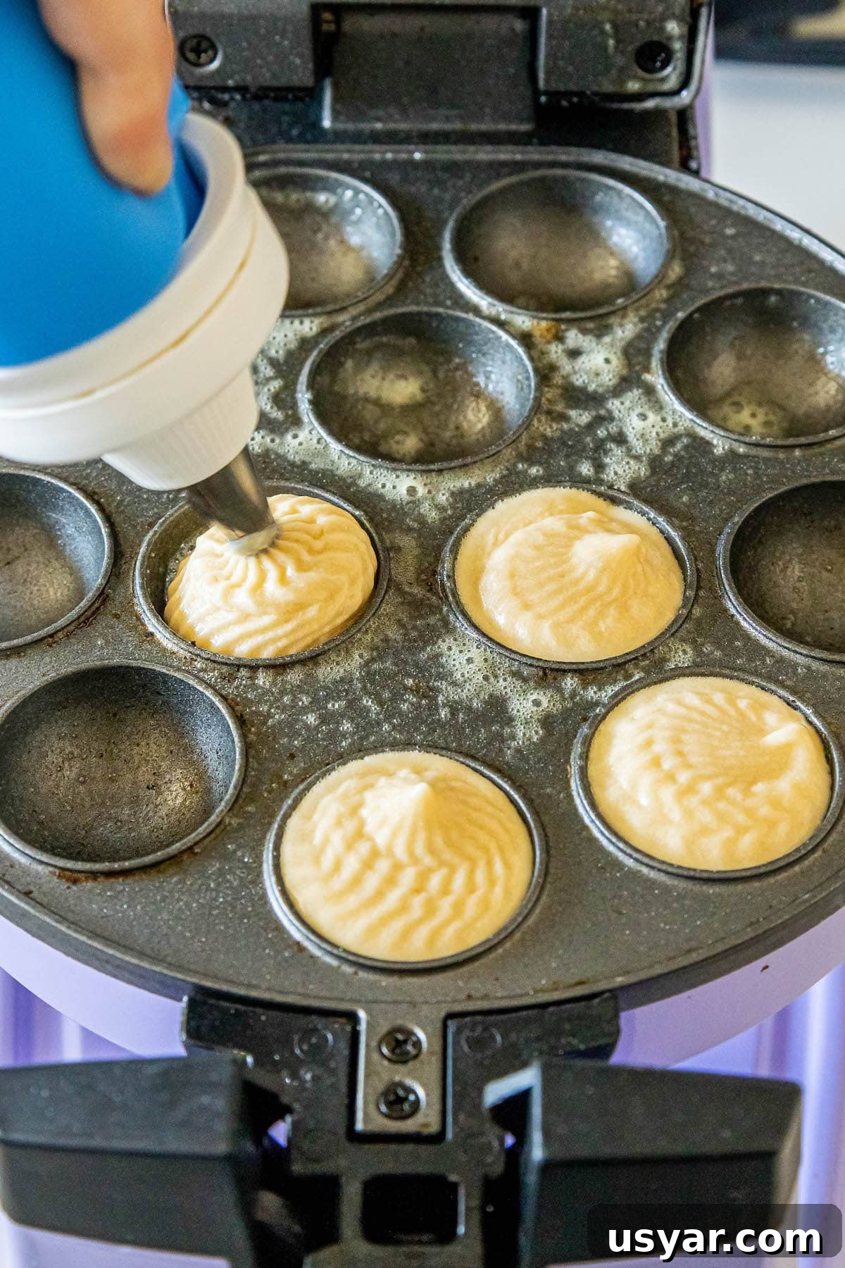 Homemade Baked Cinnamon Sugar Donut Holes Recipe 9 picture of donut holes being piped into cake pop pan