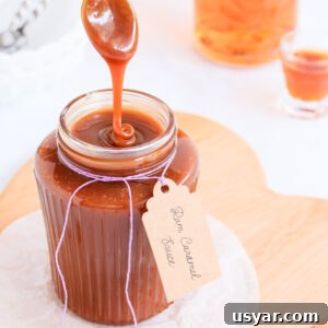 Rum Caramel Sauce Recipe 16 Rum caramel sauce falling from a spoon in a thick ribbon back into a ribbed glass jar.