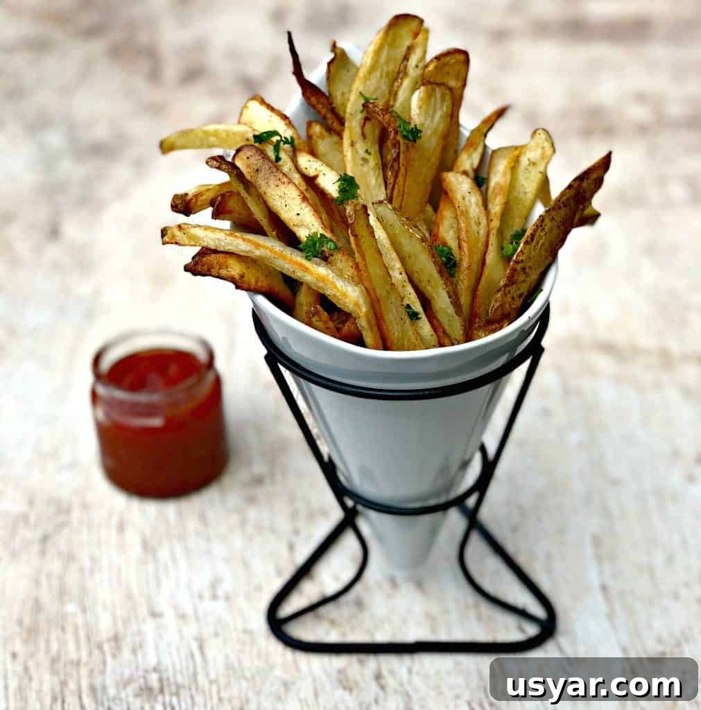 Crispy Homemade Air Fryer French Fries 9 air fryer fries spread out on a brown surface with ketchup