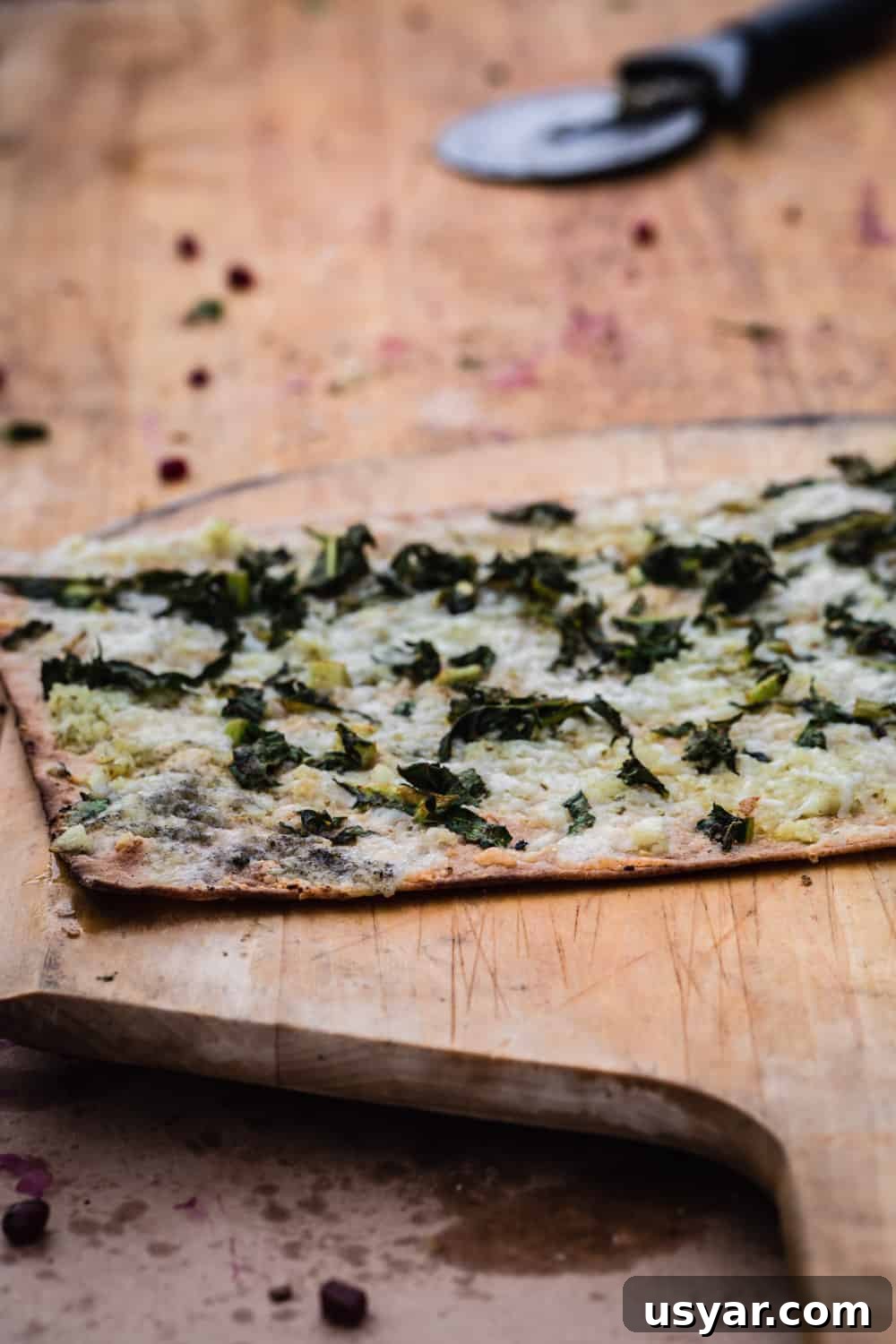 A pizza just out of the outdoor pizza oven, ready to be cut up.