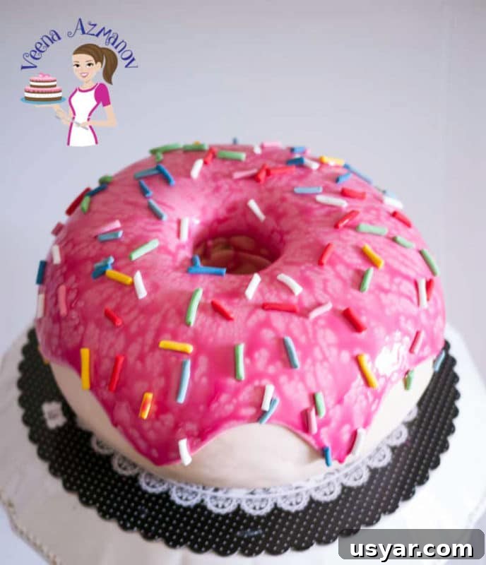 Custom Cakes for Weddings, Birthdays and Special Events 13 Pink donut cake topped with pink icing and colored sprinkles.