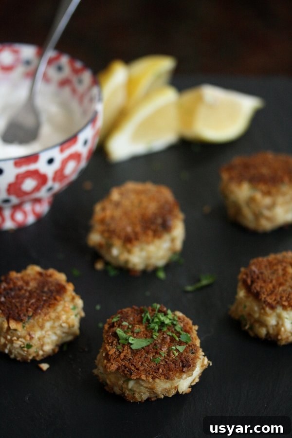 Pretzel-Crusted Gluten-Free Crab Cakes Recipe 7 gluten-free crab cakes without breadcrumbs on a plate with lemon wedges