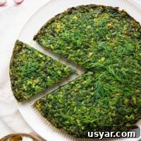 Kuku Sabzi Persian Herb Frittata Recipe 14 A bright green kuku sabzi with one slice being removed as viewed top down.