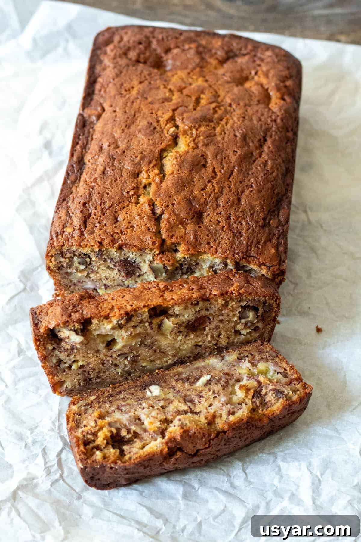 Moist Banana Bread Recipe with Ripe Bananas 2 Overhead view of banana bread loaf with two slices cut away.