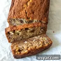 Overhead view of banana bread loaf with two slices cut away.