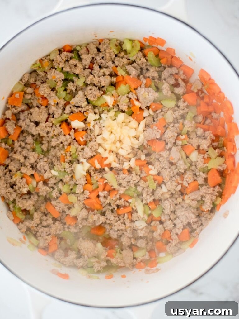 Authentic Italian Pasta e Fagioli Soup Recipe 7 garlic added to dutch oven with sausage mix