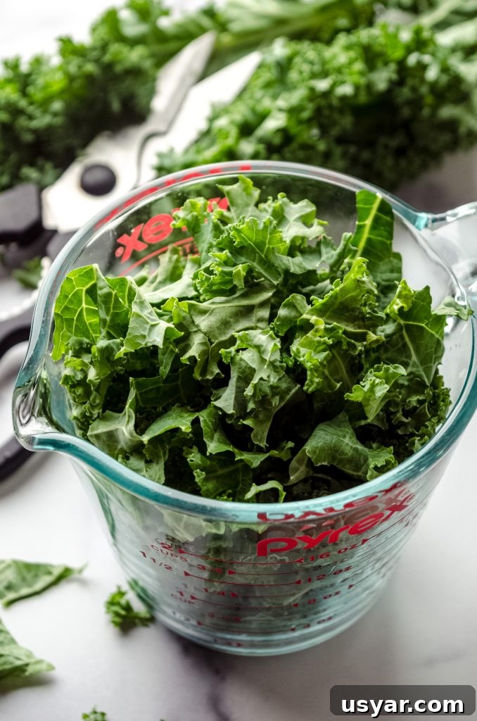 A glass measuring cup of shredded kale.