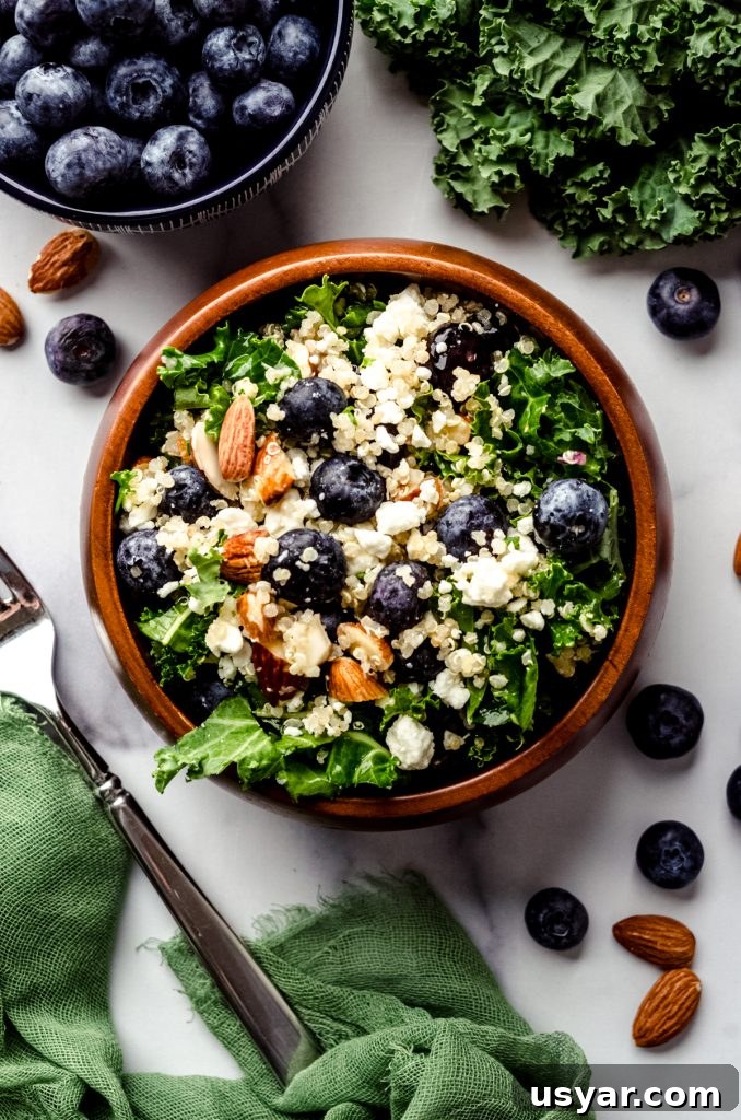 Blueberry quinoa kale salad in a small brown wooden bowl.