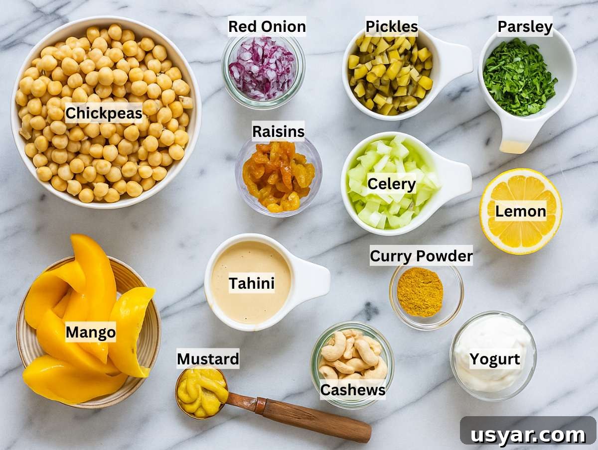 Ingredients for curry chickpea salad on a marble table.
