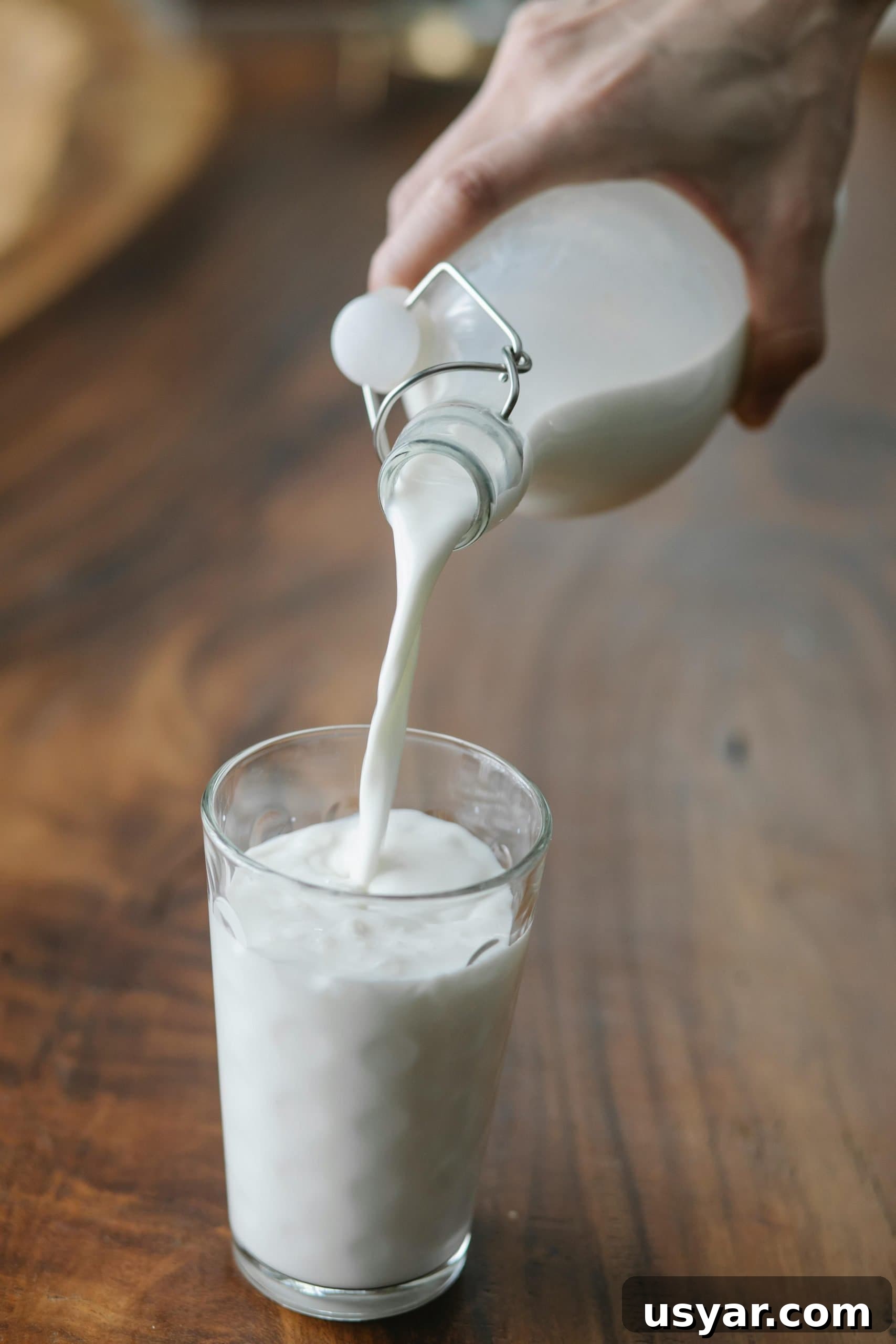 How Many Ounces in a Pint US and UK Conversions 2 Woman pouring milk into a pint glass.