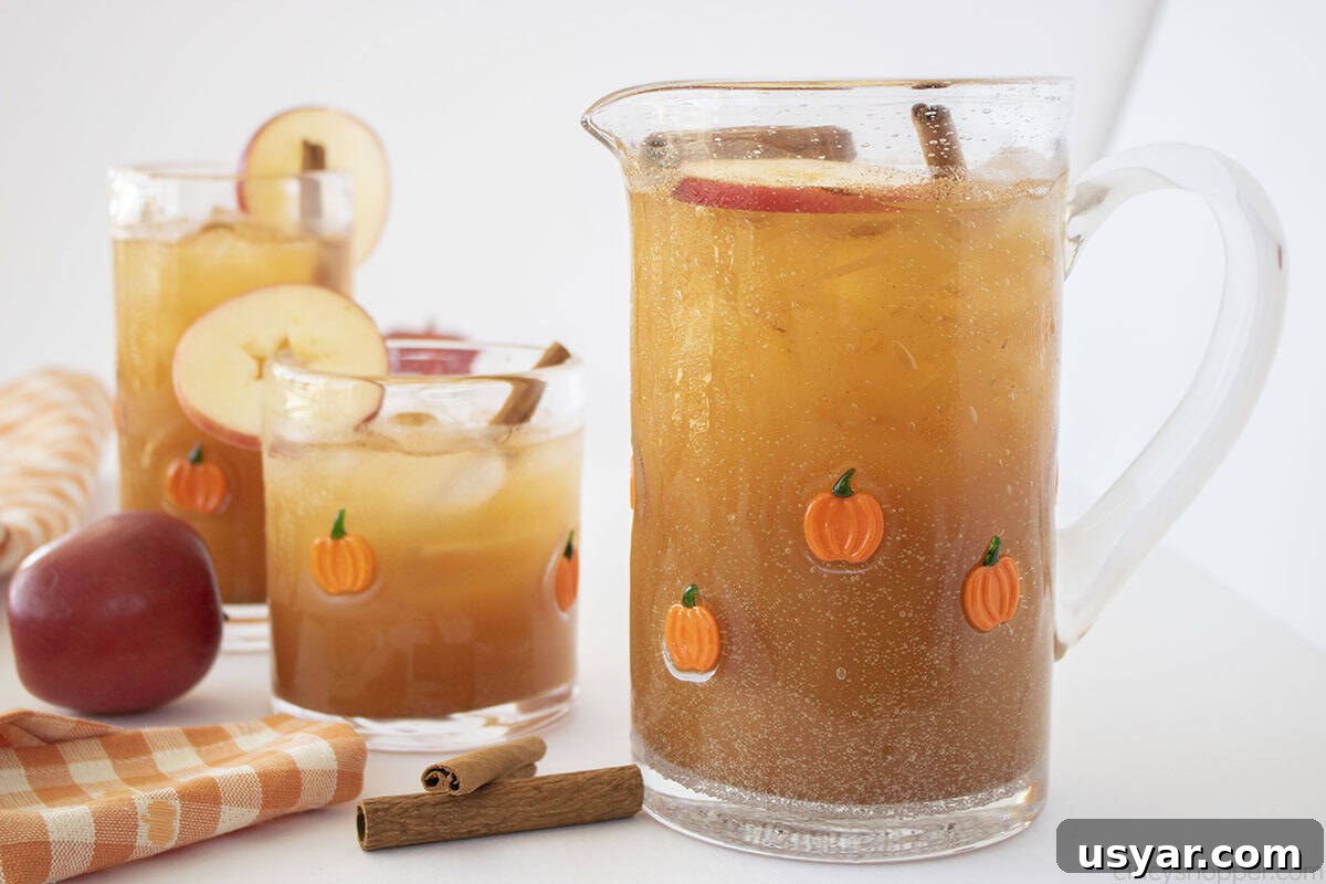 Two glasses and a pitcher filled with Thanksgiving Punch.