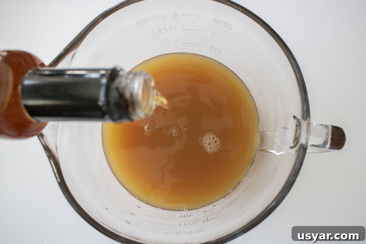 Adding caramel syrup to the apple cider in a extra large measuring cup/bowl.