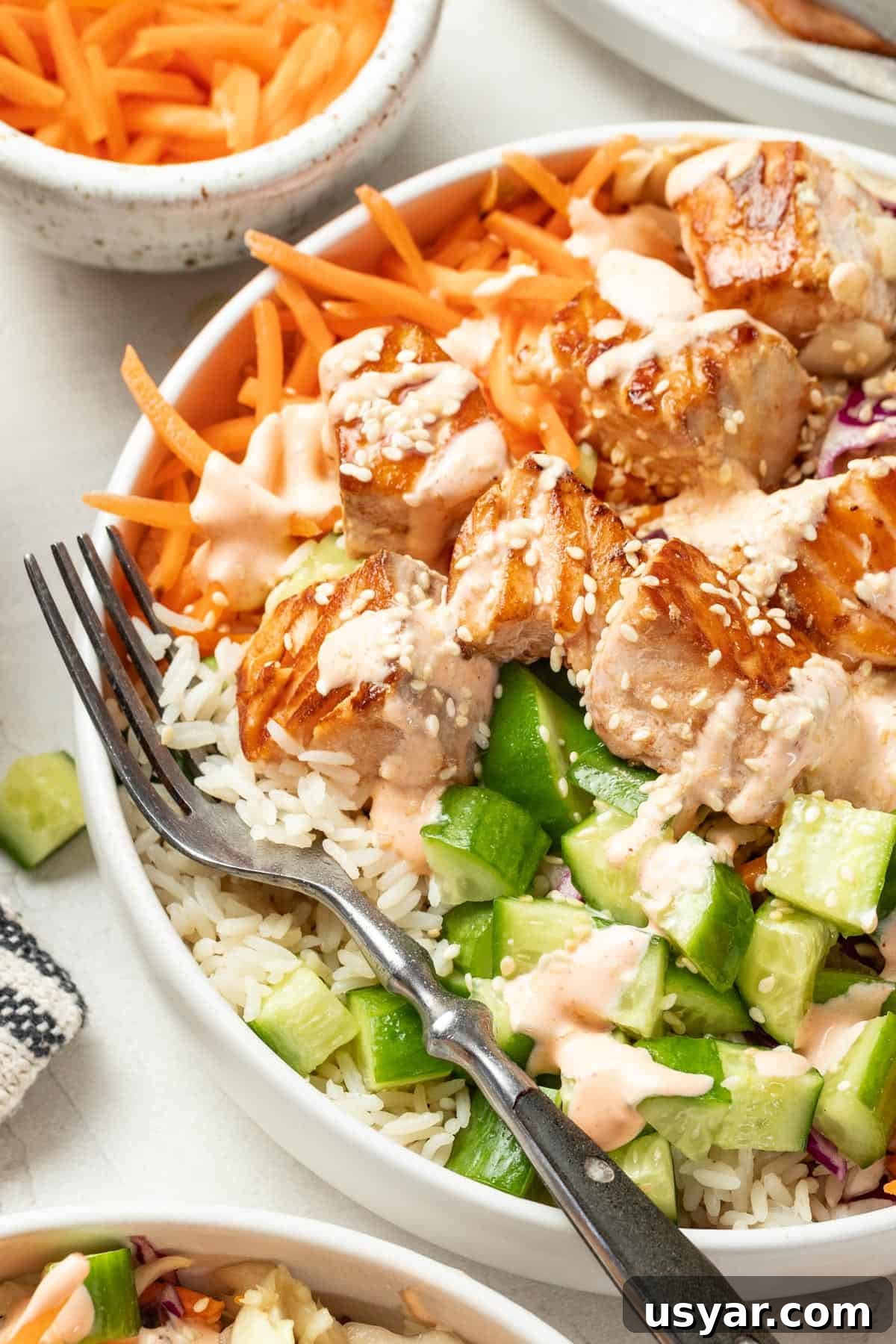 Spicy Mayo Salmon Rice Bowl 11 Spicy mayo sauce on top of a salmon bowl with a fork.