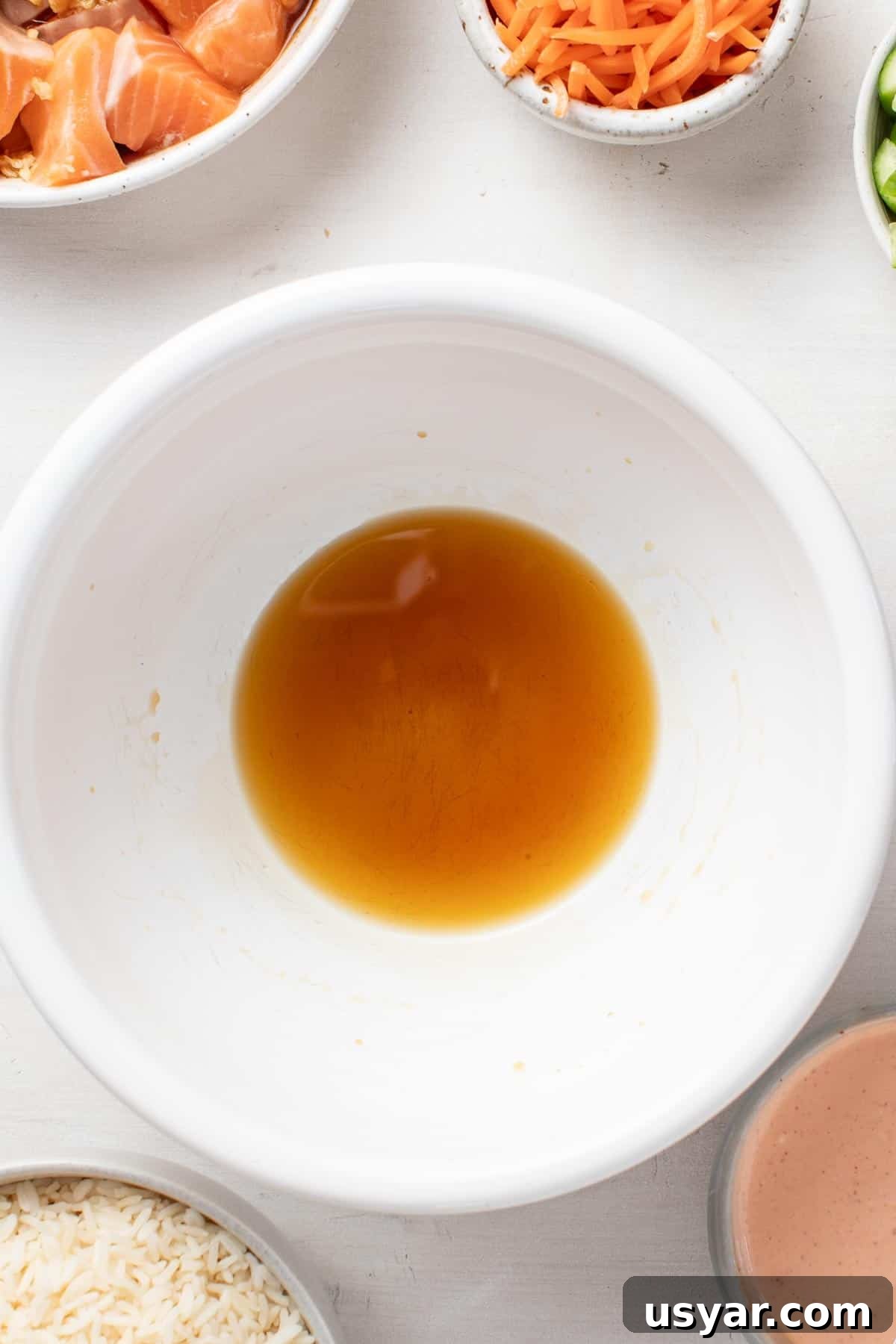 Spicy Mayo Salmon Rice Bowl 4 Stirring the coconut aminos and sesame oil together in a small white bowl.