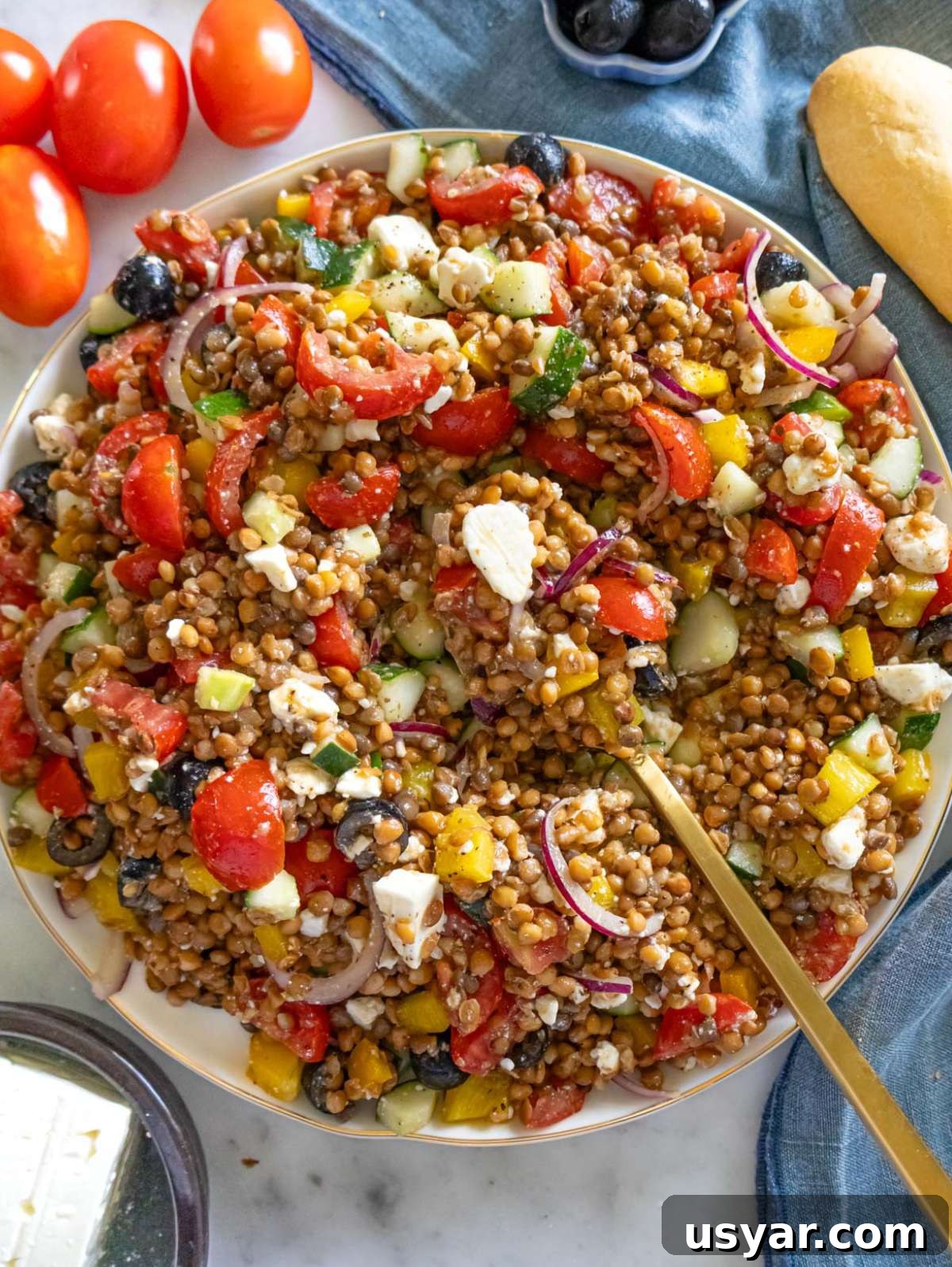 Greek Lentil Salad with Tangy Lemon-Herb Dressing 2 Top down Greek lentil salad on a large platter with colorful vegetables and feta.
