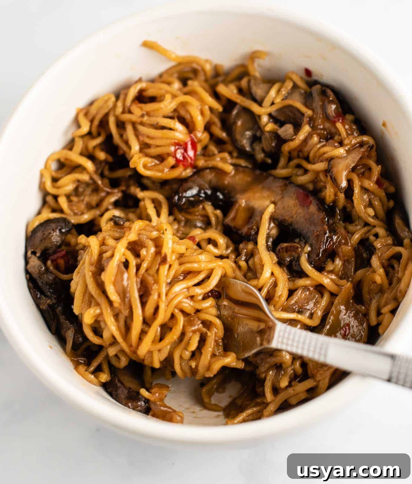 Umami Mushroom Ramen Noodles with Savory Broth 4 stir fry noodles with mushrooms and sweet chili sauce in a white bowl