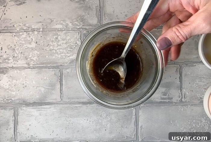 Balsamic dressing in a glass bowl with a spoon.