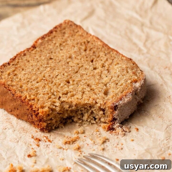 a slice of apple cider donut bread on parchment paper, a piece broken off