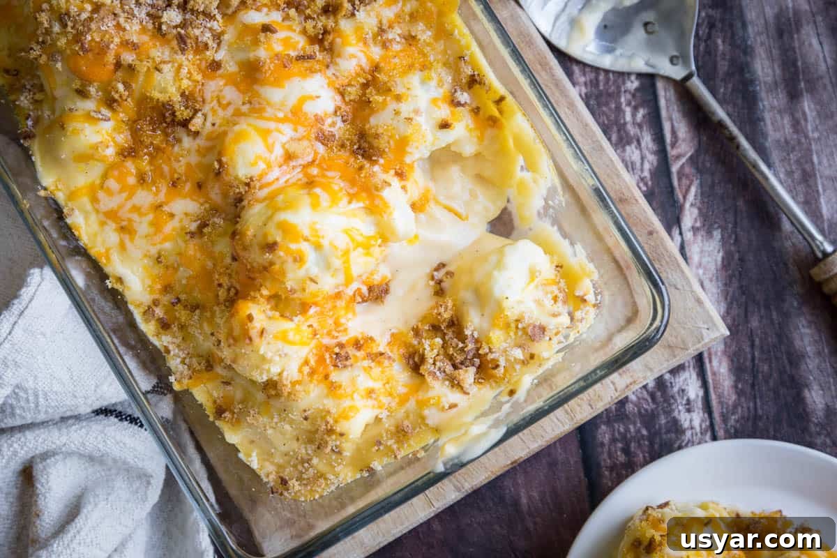 Cornflour vs Cornstarch vs Cornmeal: Key Differences & Uses 5 overhead shot of Gluten-Free Cauliflower Cheese in a serving dish with a spoon on a wooden board