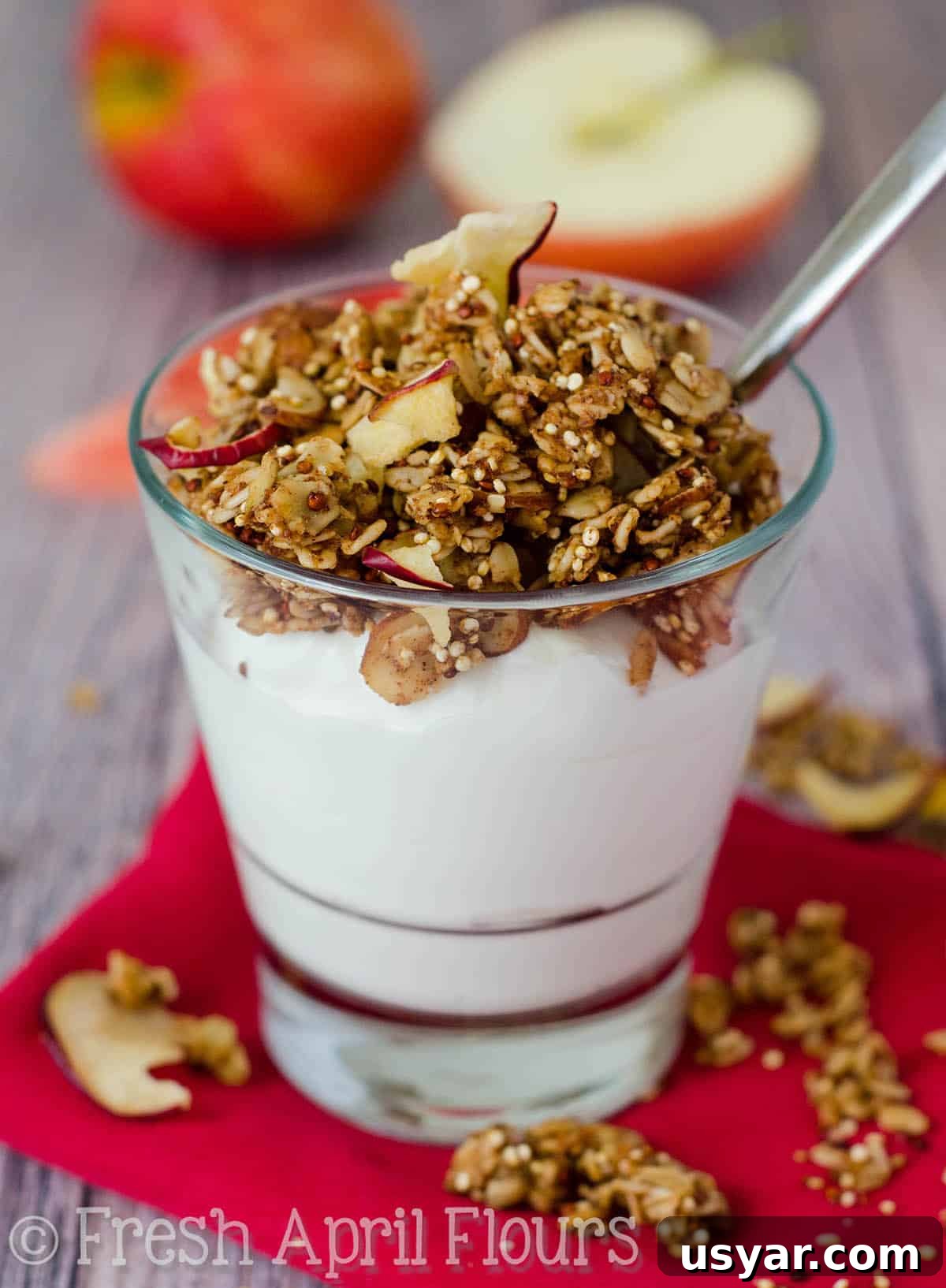 Crispy Apple Quinoa Granola Recipe 6 Apple quinoa granola on top of a cup of yogurt with a spoon in it.