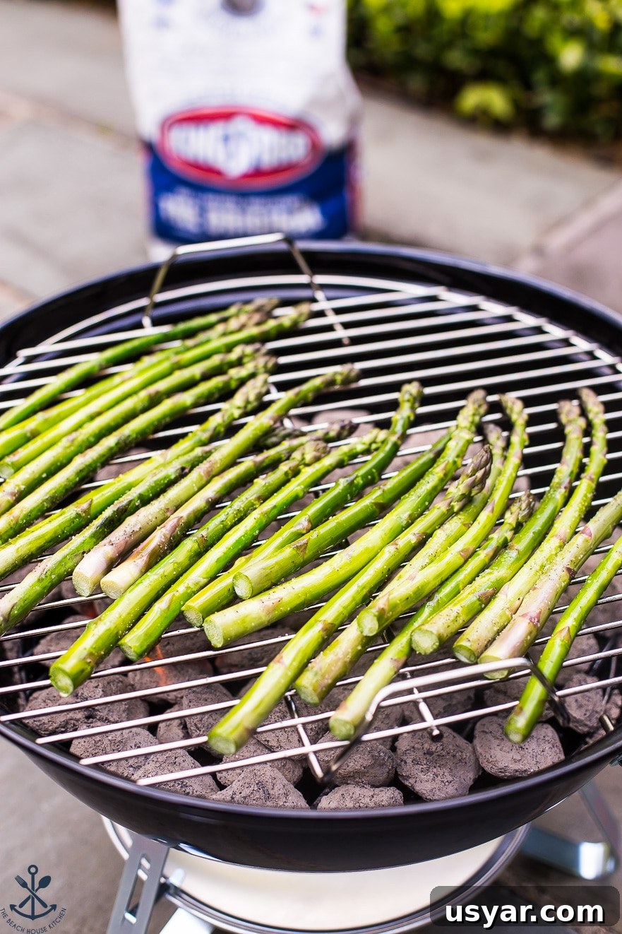 Charred Grilled Asparagus Salad with Lemon Vinaigrette 7 Asparagus grilling on a small round charcoal grill