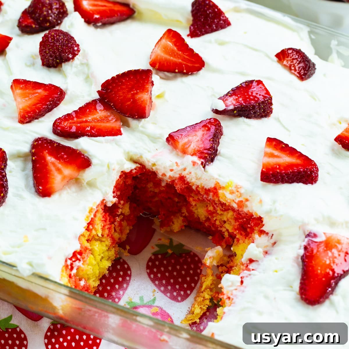 Refreshing Strawberry Lemonade Poke Cake 6 Cake in baking pan with slice removed.