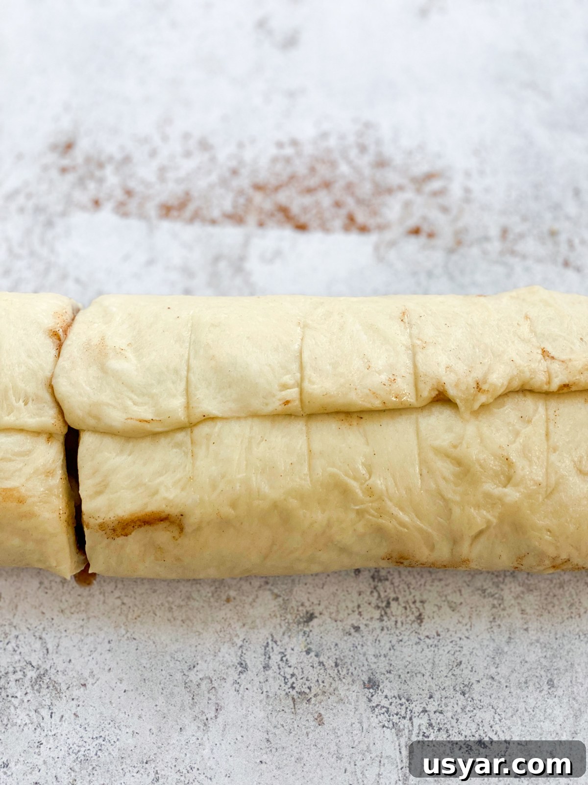 Cinnamon Rolls Stuffed with Apple Pie Filling 12 cutting into rolls.
