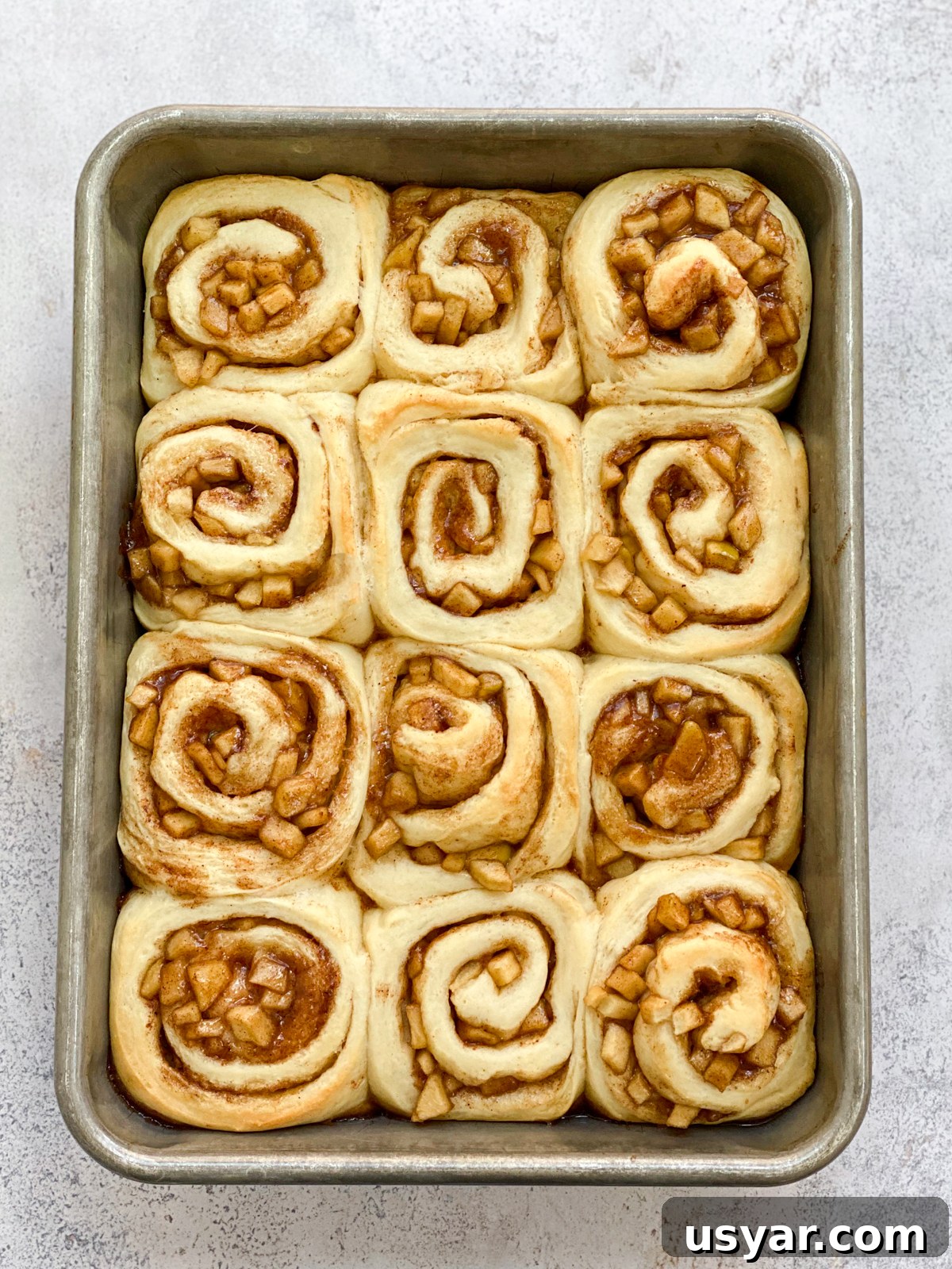 Cinnamon Rolls Stuffed with Apple Pie Filling 13 cinnamon rolls with apple pie filling baked before frosting.