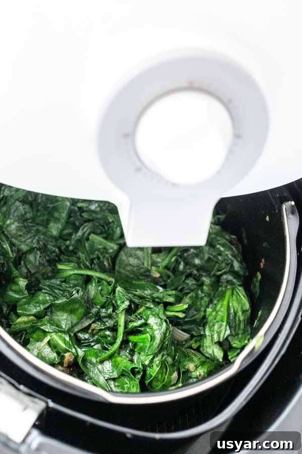 Crispy Garlic Air Fryer Spinach 2 Spinach in an Air Fryer made with an Air Fryer barrel. Ready to be served as a tasty side dish.