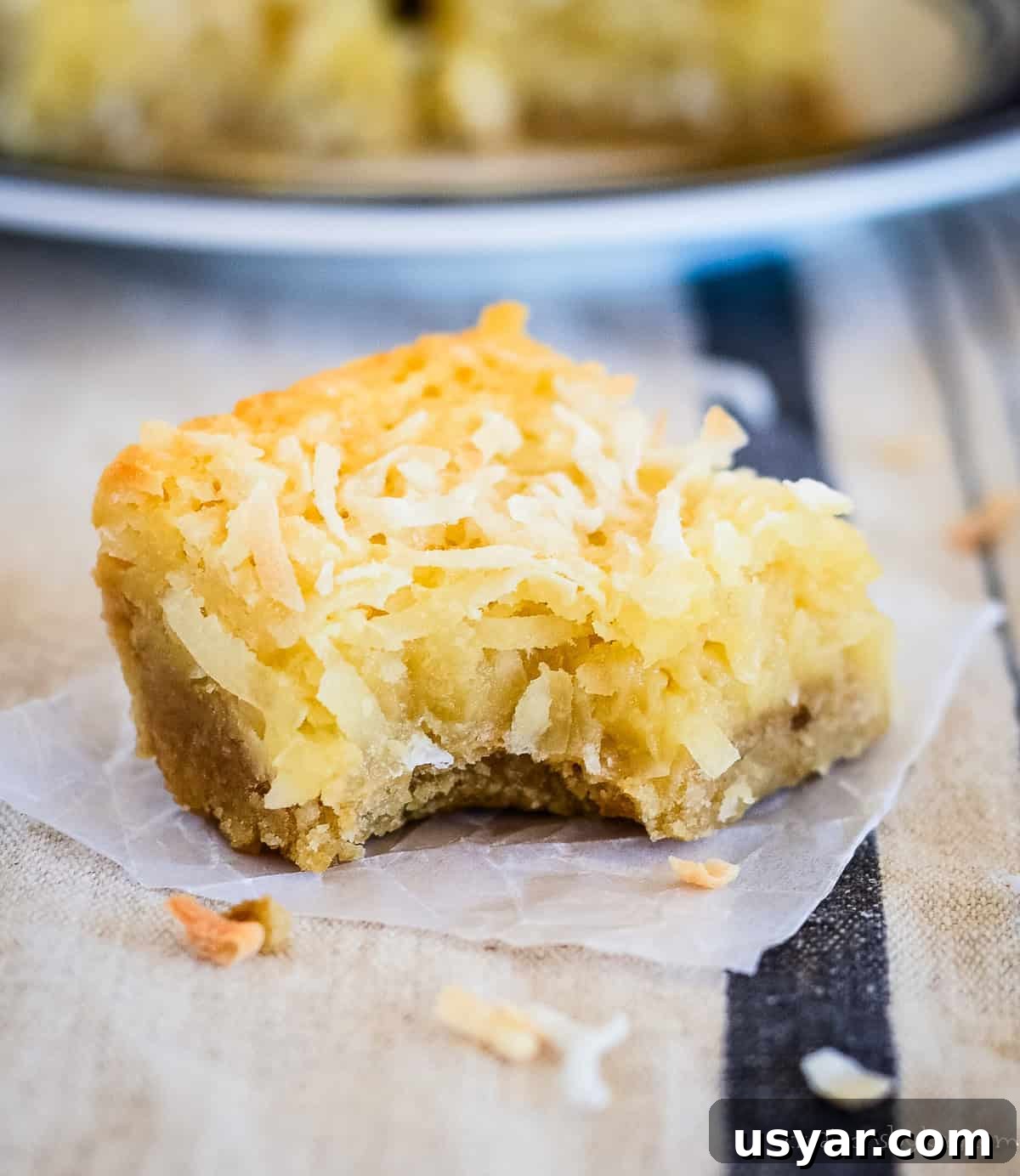 Homemade Chewy Buttery Coconut Bars 7 chewy coconut bar with a bite taken out of it