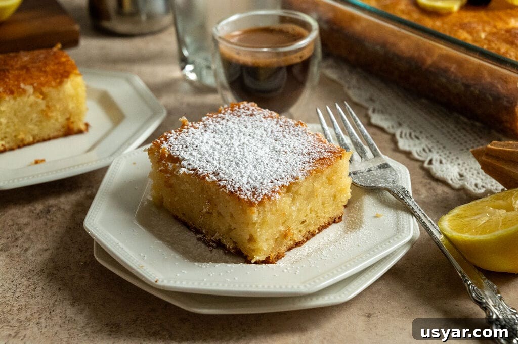 Lemonopita: Greek Lemon Cake with Phyllo 2 A piece of lemonopita cake on a white plate, and topped with a sprinkle of icing sugar, with a Greek coffee next to it.