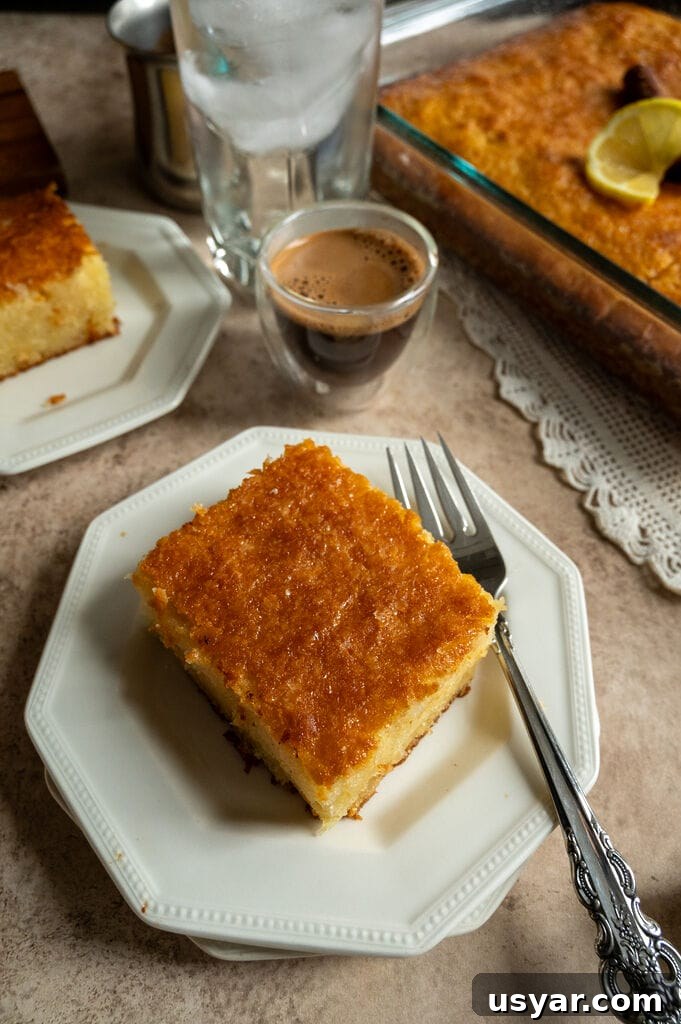 Lemonopita: Greek Lemon Cake with Phyllo 3 A piece of lemonopita cake on a white plate, with a Greek coffee next to it.